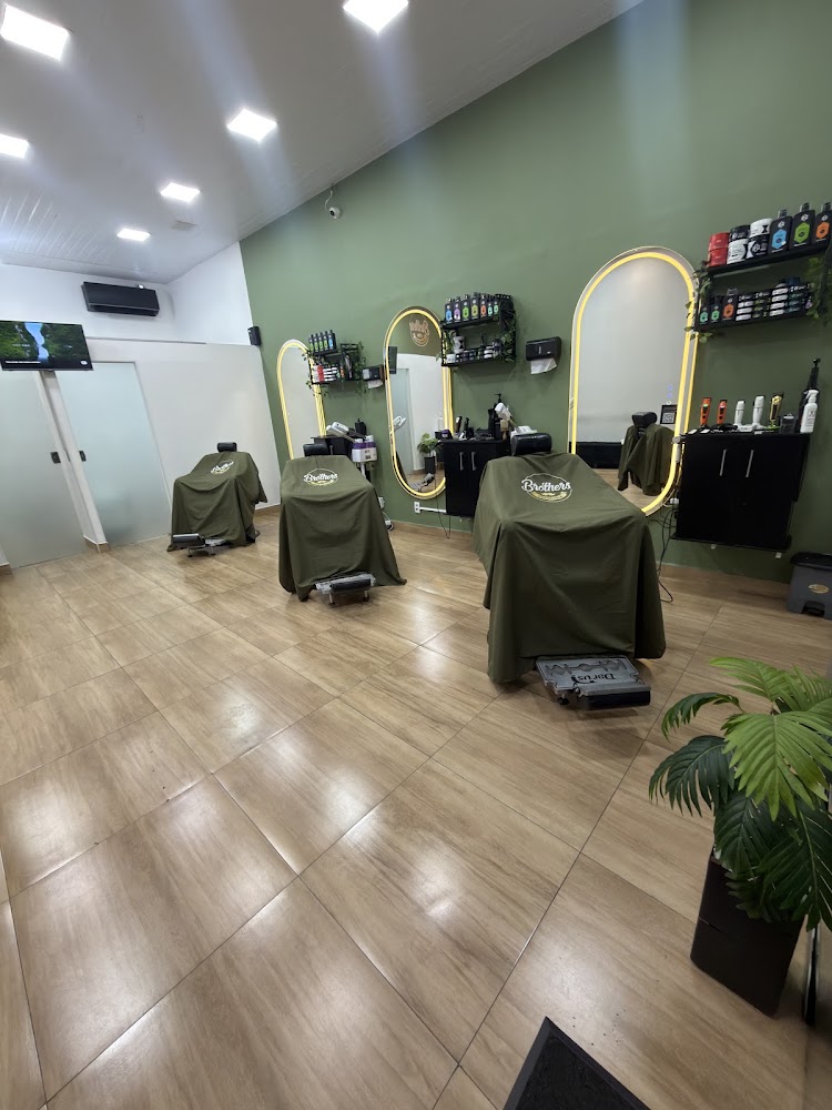 Salão da Brother's Barbearia com três cadeiras, espelhos iluminados e parede verde